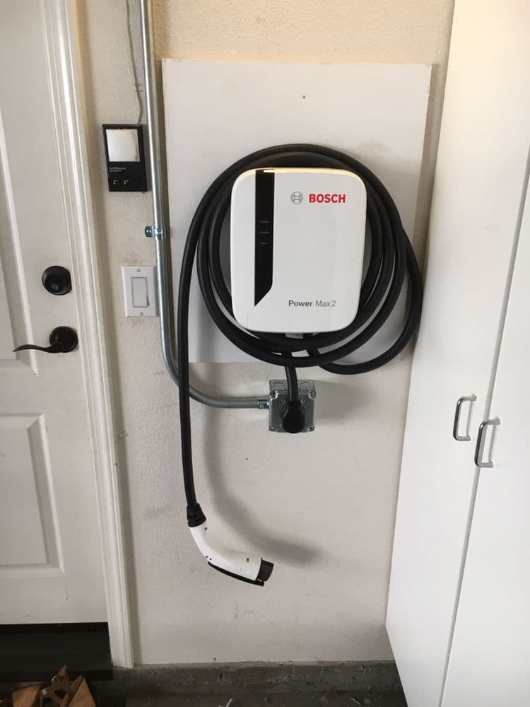Bosch Power Max 2 electric vehicle charger mounted on wall with charging cable.