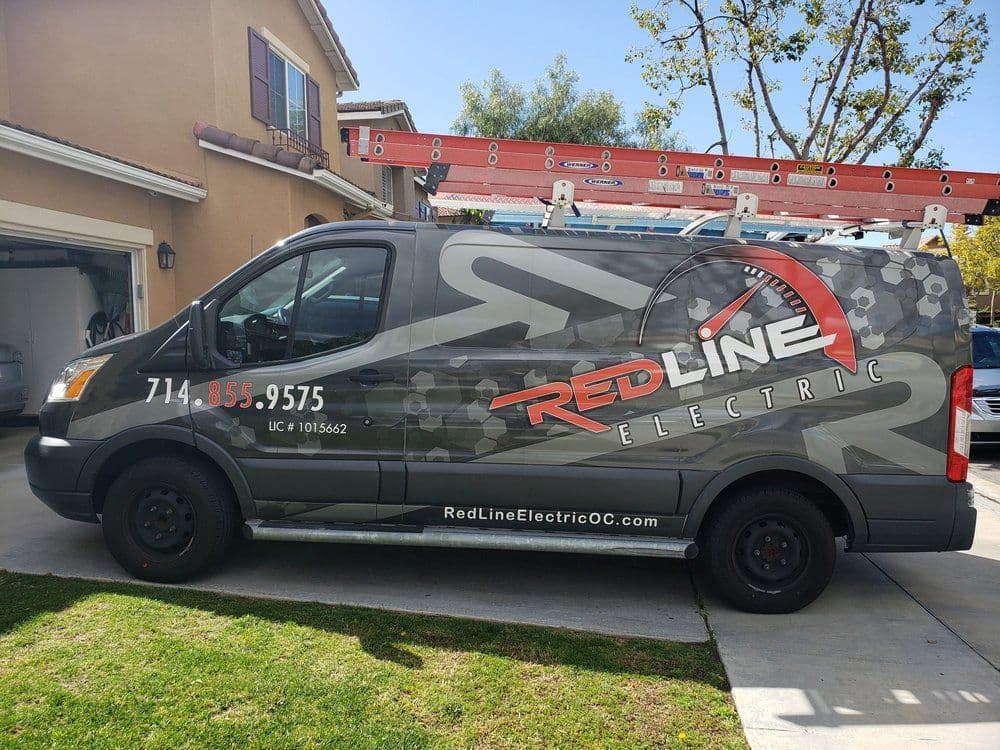 Red Line Electric service van parked outside a residential home with ladder and logo visible.