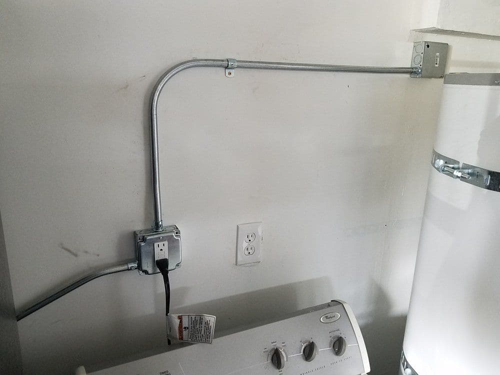 Electrical wiring and outlet installation near a washing machine and water heater.
