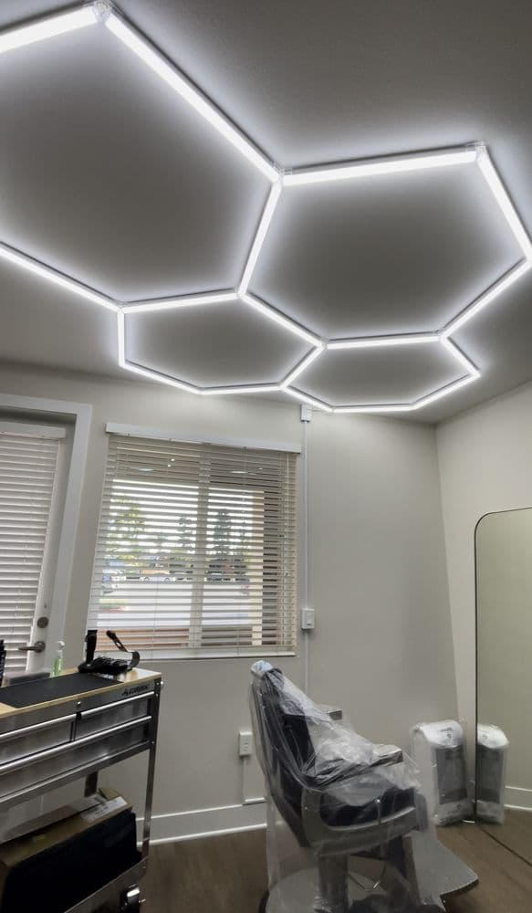 Modern salon interior with hexagon LED ceiling lights and ergonomic styling chair.